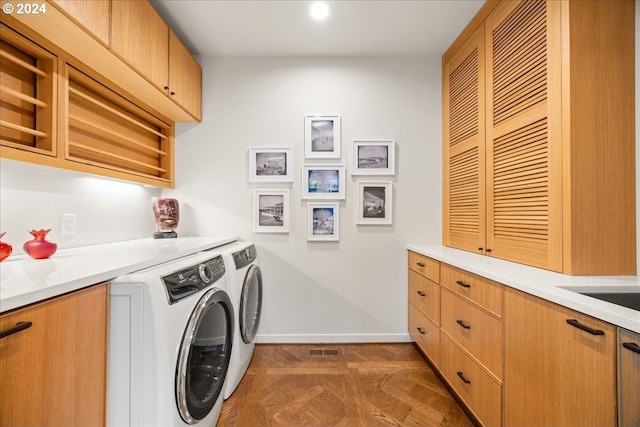 washroom with cabinets, separate washer and dryer, and dark parquet floors