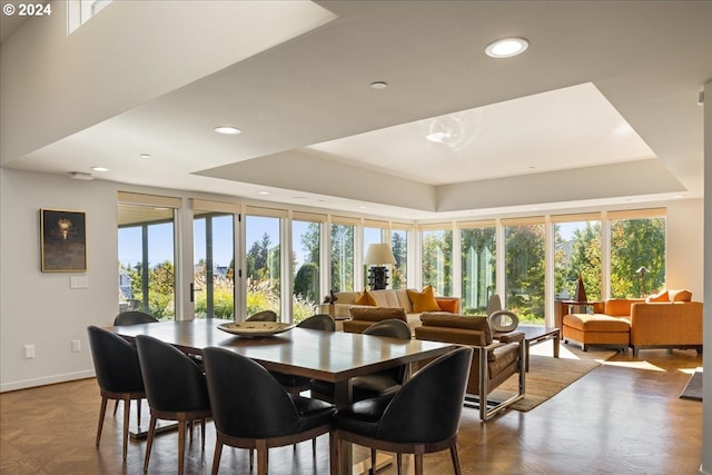 interior space featuring parquet floors, a tray ceiling, and a wealth of natural light