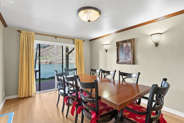 dining room featuring crown molding and light wood-type flooring