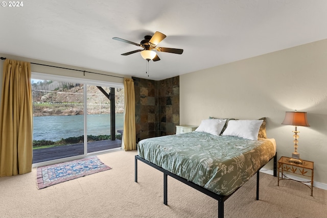 bedroom featuring carpet floors, ceiling fan, and a water view