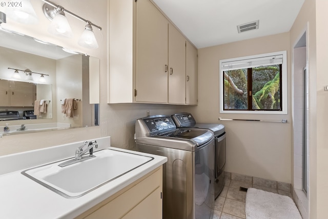 laundry area featuring washing machine and dryer, sink, and light tile patterned flooring