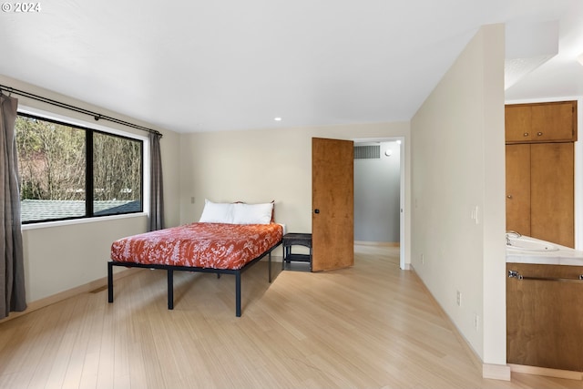 bedroom featuring sink and light hardwood / wood-style floors