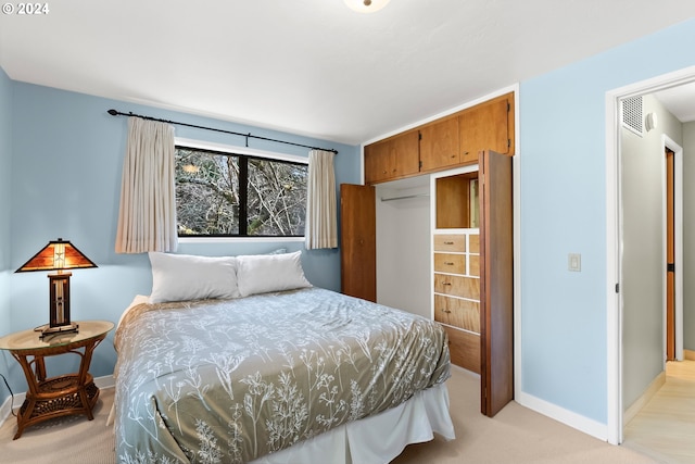 bedroom featuring light colored carpet and a closet