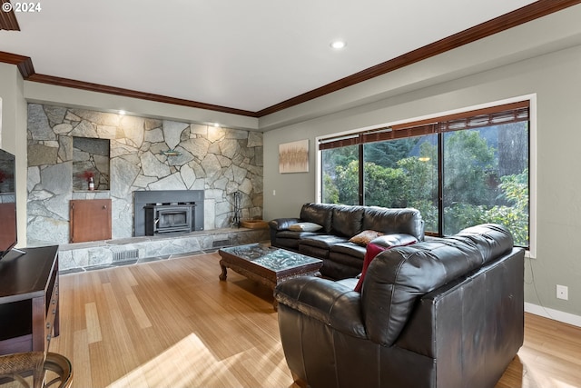 living room featuring crown molding, a fireplace, and light wood-type flooring