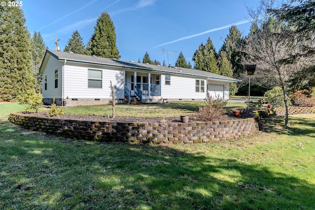 back of house with crawl space, covered porch, a yard, and an attached garage