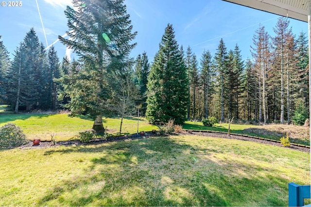 view of yard with a view of trees