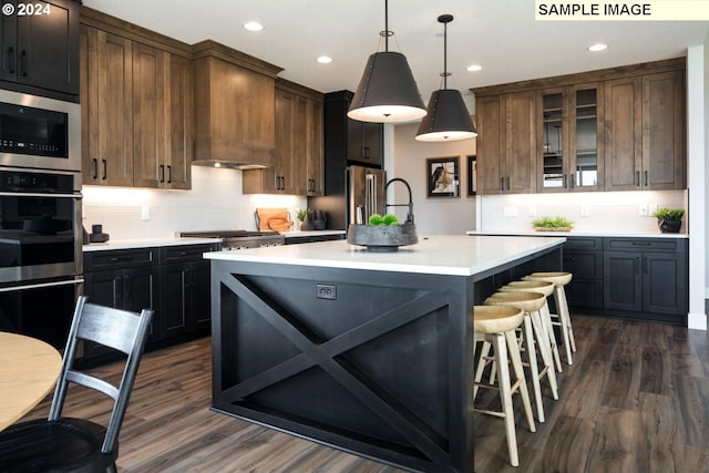 kitchen featuring an island with sink, dark hardwood / wood-style floors, and stainless steel appliances