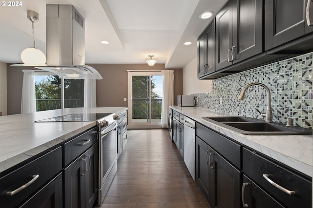 kitchen featuring dark wood-type flooring, stainless steel appliances, sink, decorative light fixtures, and tasteful backsplash