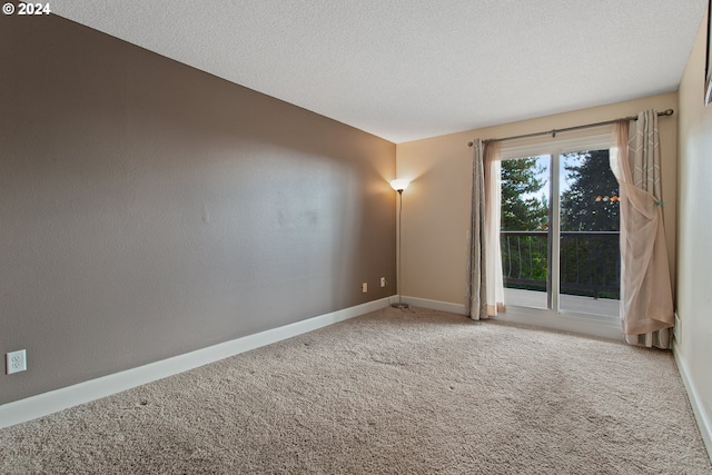 spare room featuring a textured ceiling and carpet