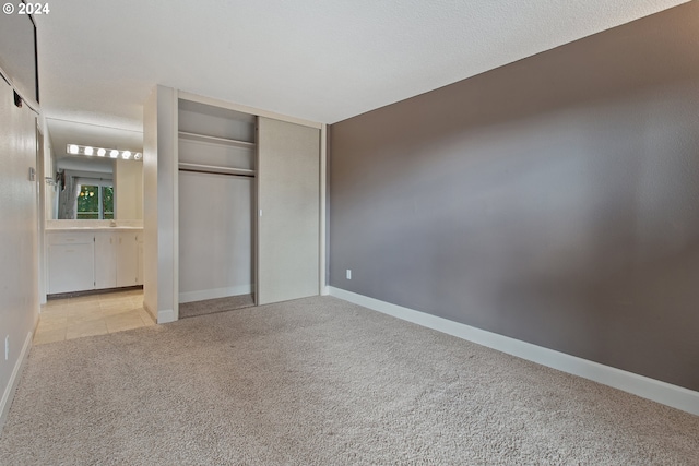 unfurnished bedroom featuring light colored carpet and a closet