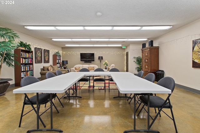 dining area featuring a textured ceiling and concrete flooring