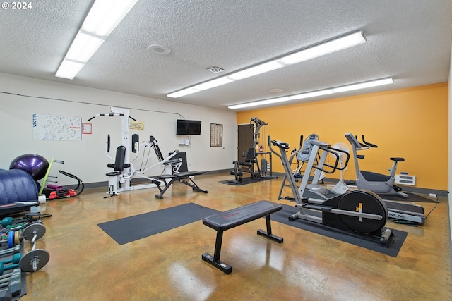 workout area featuring concrete floors and a textured ceiling