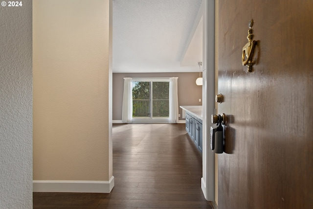 hallway featuring a textured ceiling and dark hardwood / wood-style flooring