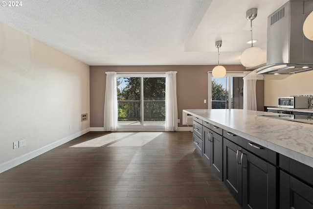 kitchen featuring island range hood, dark wood-type flooring, hanging light fixtures, and a healthy amount of sunlight