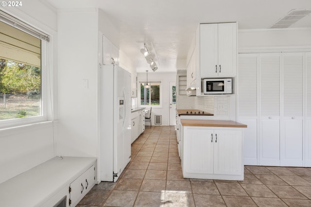 kitchen featuring white appliances, white cabinets, hanging light fixtures, light tile patterned floors, and butcher block countertops