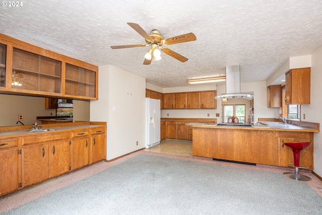 kitchen featuring white fridge with ice dispenser, kitchen peninsula, light colored carpet, and island range hood