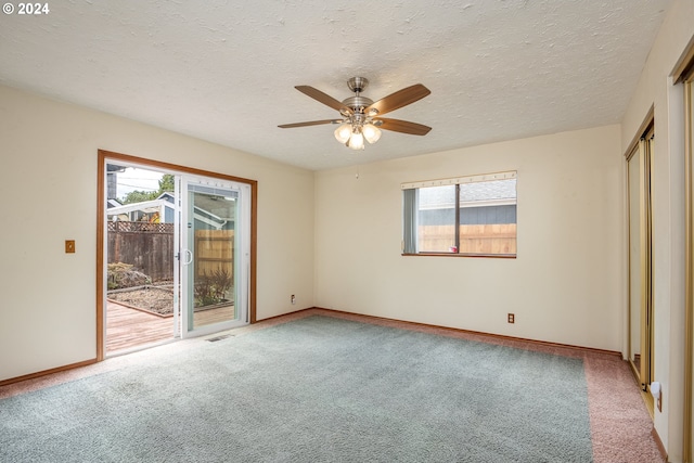 unfurnished bedroom with ceiling fan, carpet flooring, a textured ceiling, and access to exterior