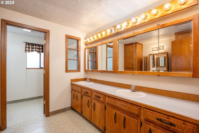 bathroom featuring a textured ceiling, tile patterned flooring, and vanity