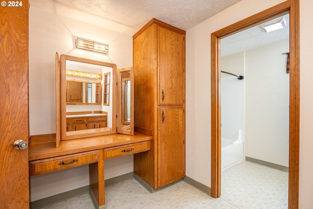 bathroom featuring a textured ceiling, vanity, and tile patterned floors