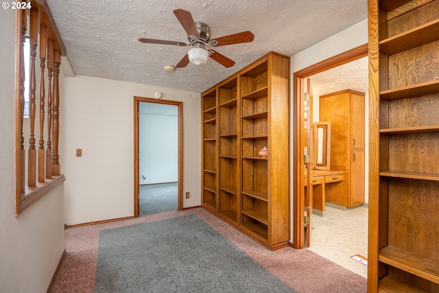 interior space with ceiling fan, light colored carpet, and a textured ceiling