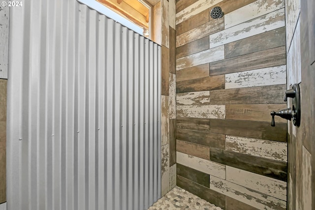 bathroom with walk in shower and wood walls