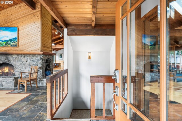 interior space with beamed ceiling, wood ceiling, tile patterned floors, and wood walls