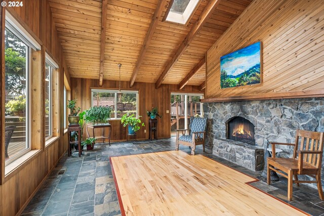 unfurnished sunroom with a fireplace, wooden ceiling, and lofted ceiling with skylight