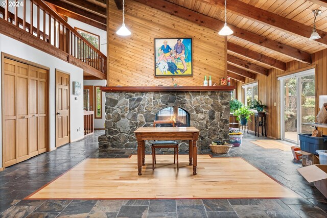 living room with wood ceiling, wooden walls, beamed ceiling, and tile patterned floors