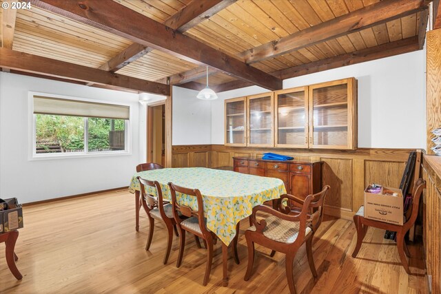 dining room featuring light wood-type flooring, beam ceiling, and wood ceiling