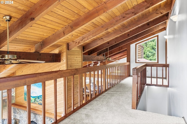 hallway with vaulted ceiling with beams, carpet flooring, wooden walls, and wood ceiling