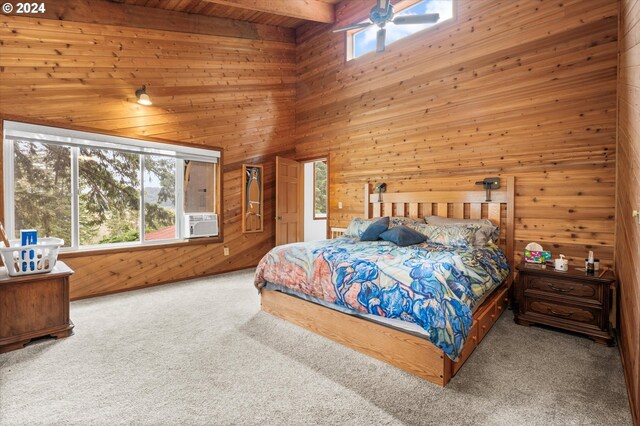 bedroom featuring beam ceiling, wooden walls, ceiling fan, a towering ceiling, and light carpet