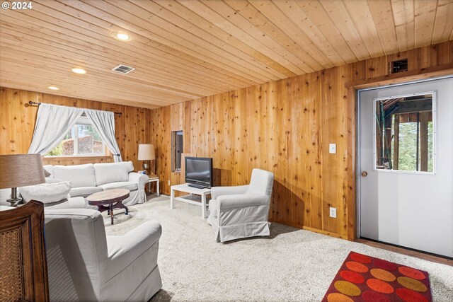 carpeted living room with wooden walls and wooden ceiling