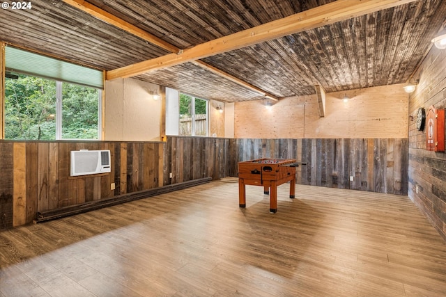 interior space featuring wood walls, light hardwood / wood-style flooring, beam ceiling, and a wall unit AC