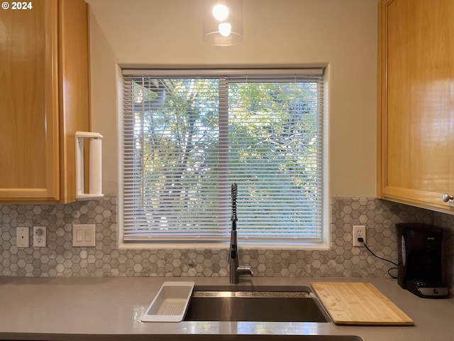 kitchen with light brown cabinets, backsplash, and sink