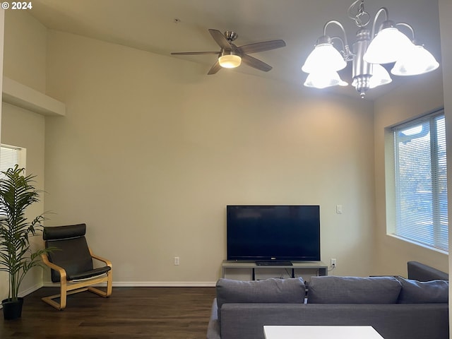 living room featuring ceiling fan with notable chandelier and dark hardwood / wood-style flooring