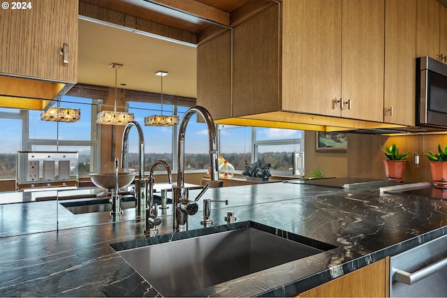 kitchen featuring beam ceiling, sink, an inviting chandelier, pendant lighting, and appliances with stainless steel finishes