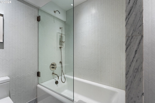 bathroom featuring tiled shower / bath combo and toilet