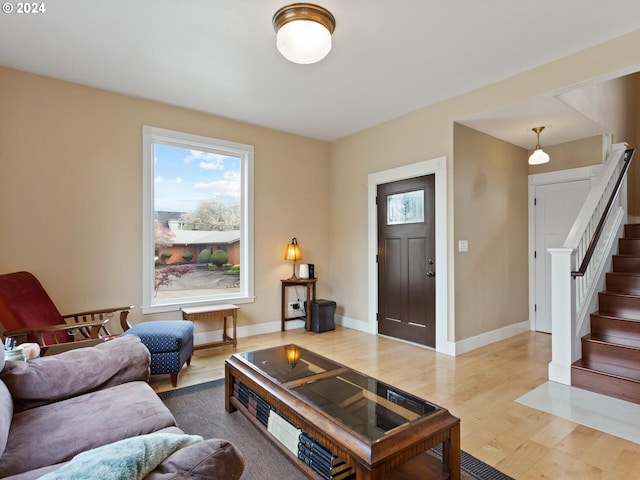 living area featuring stairs, wood finished floors, and baseboards