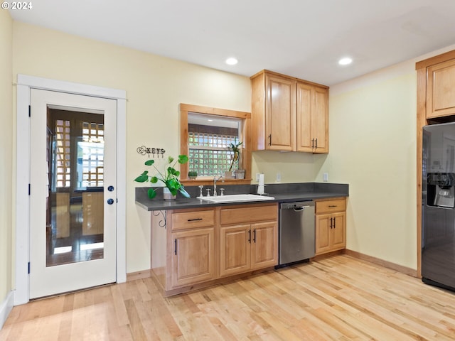 kitchen with a sink, light wood-style floors, dishwasher, dark countertops, and black refrigerator with ice dispenser