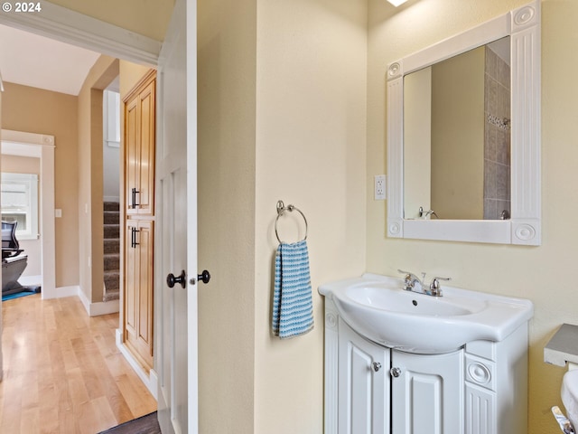 bathroom with baseboards, wood finished floors, and vanity