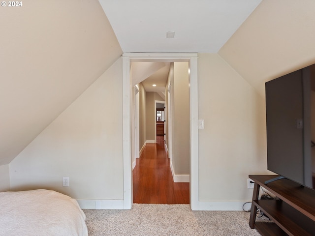 bedroom featuring vaulted ceiling, baseboards, and carpet floors