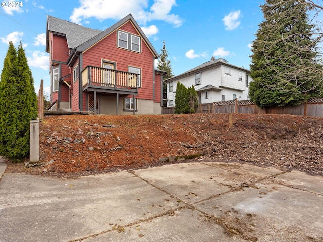 rear view of property with a wooden deck and fence