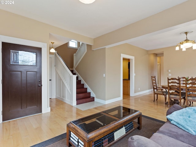 living room featuring baseboards, wood finished floors, and stairs