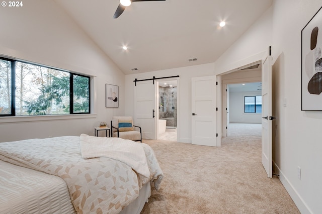 carpeted bedroom with high vaulted ceiling, a barn door, ceiling fan, and ensuite bathroom