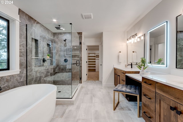 bathroom featuring shower with separate bathtub and vanity