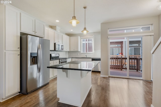 kitchen with white cabinets, stainless steel appliances, and hardwood / wood-style flooring