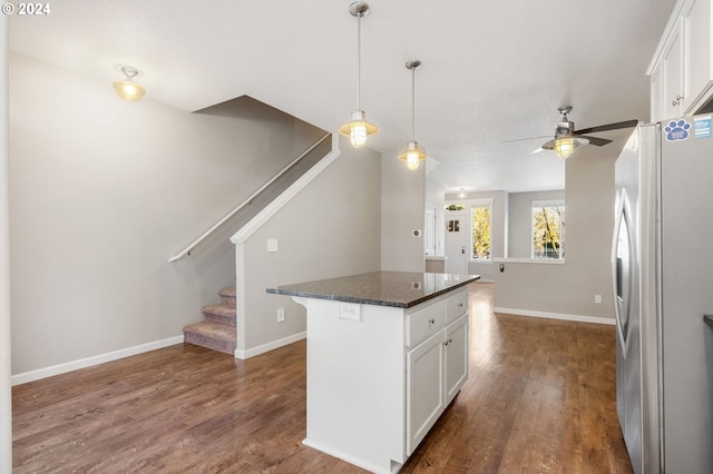 kitchen featuring white fridge, a kitchen island, dark hardwood / wood-style flooring, and white cabinetry