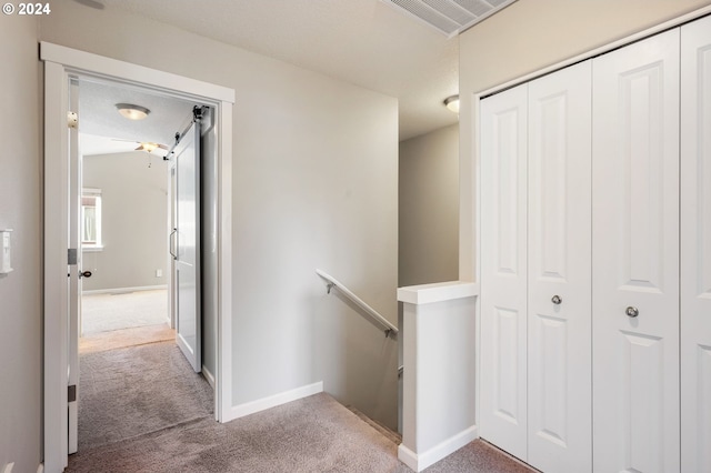 hallway with carpet floors and a textured ceiling