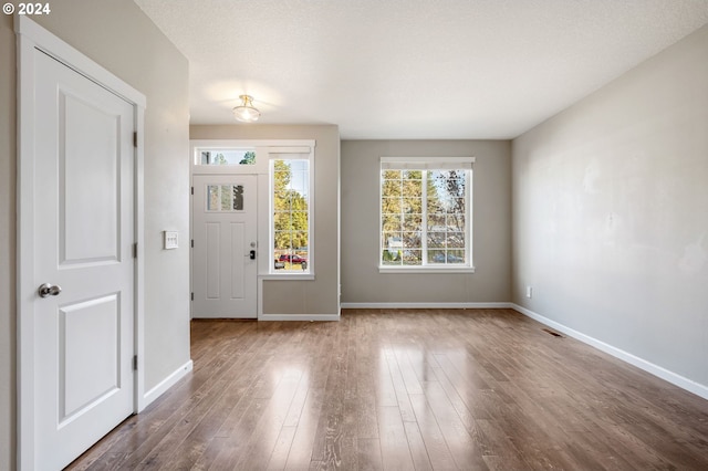 entryway with hardwood / wood-style floors and a textured ceiling