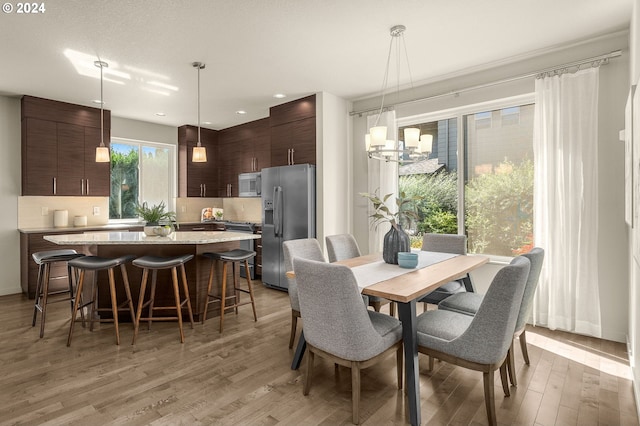 dining room with light hardwood / wood-style flooring and an inviting chandelier